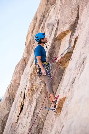 Grimpeur en pleine action sur une falaise rocheuse à Loudenvielle